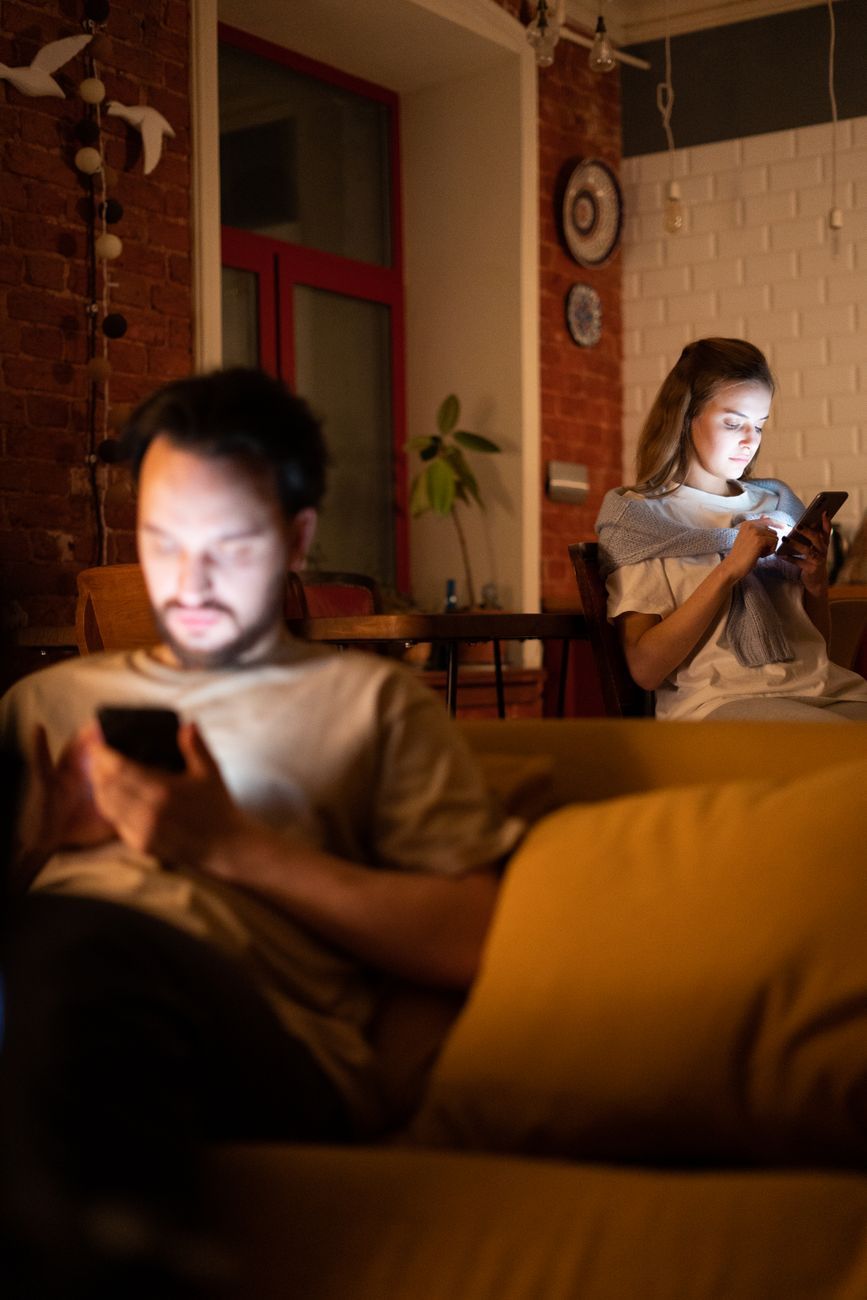 Casal no sofá, cada um no seu celular